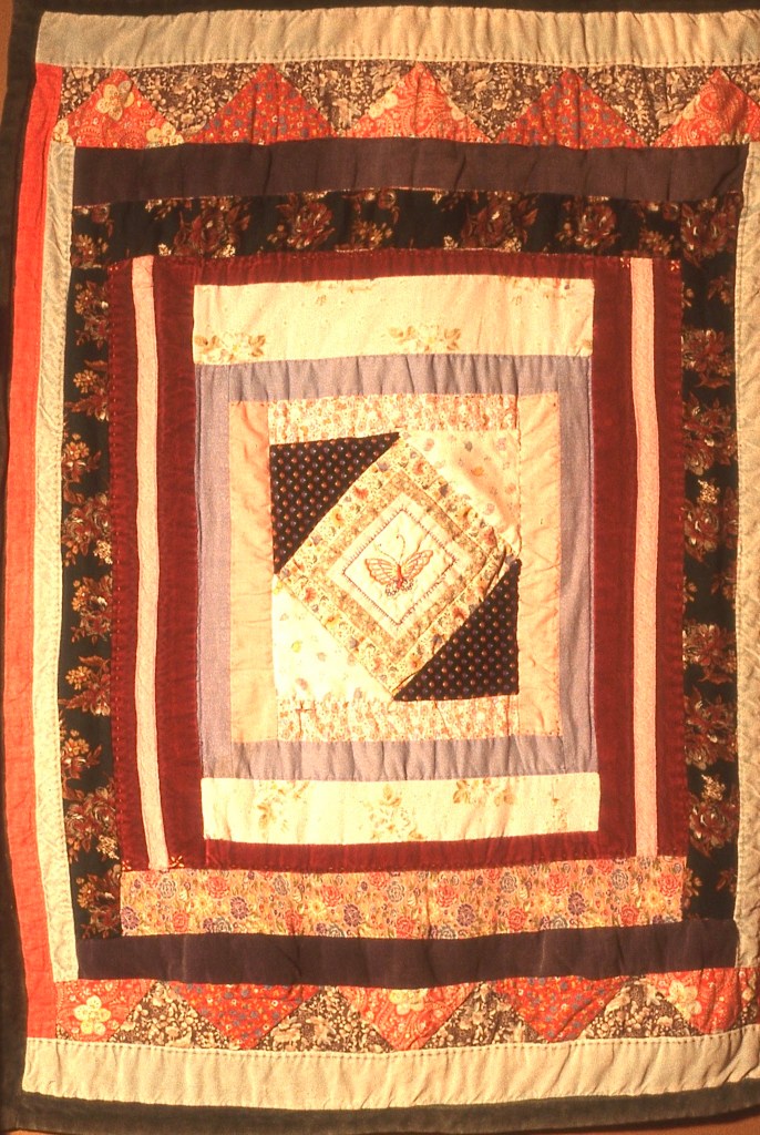 There's an embroidered butterfly in the middle of this baby quilt